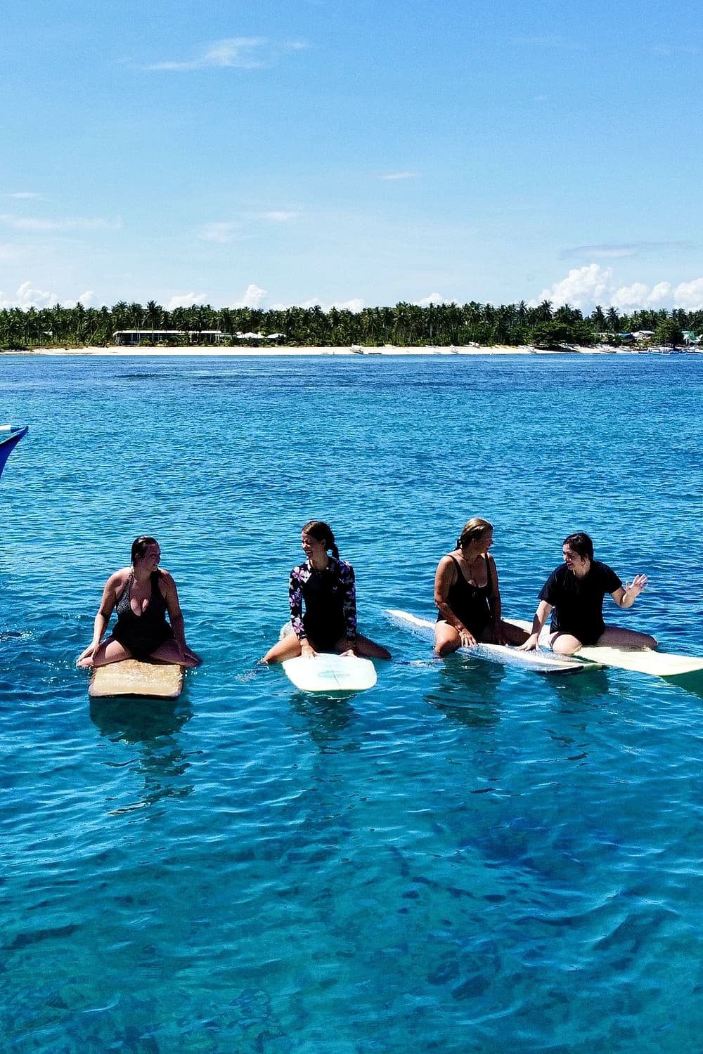 Group surf lesson on boards in the turquoise water off Siargao