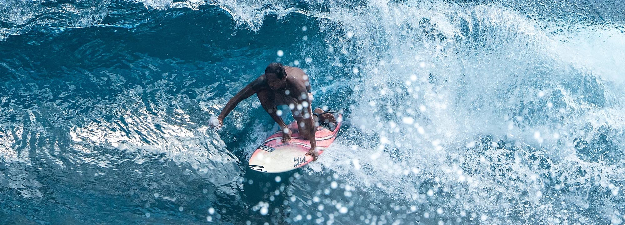 Surfer carving deep in the pocket of a wave at Cloud 9, Siargao