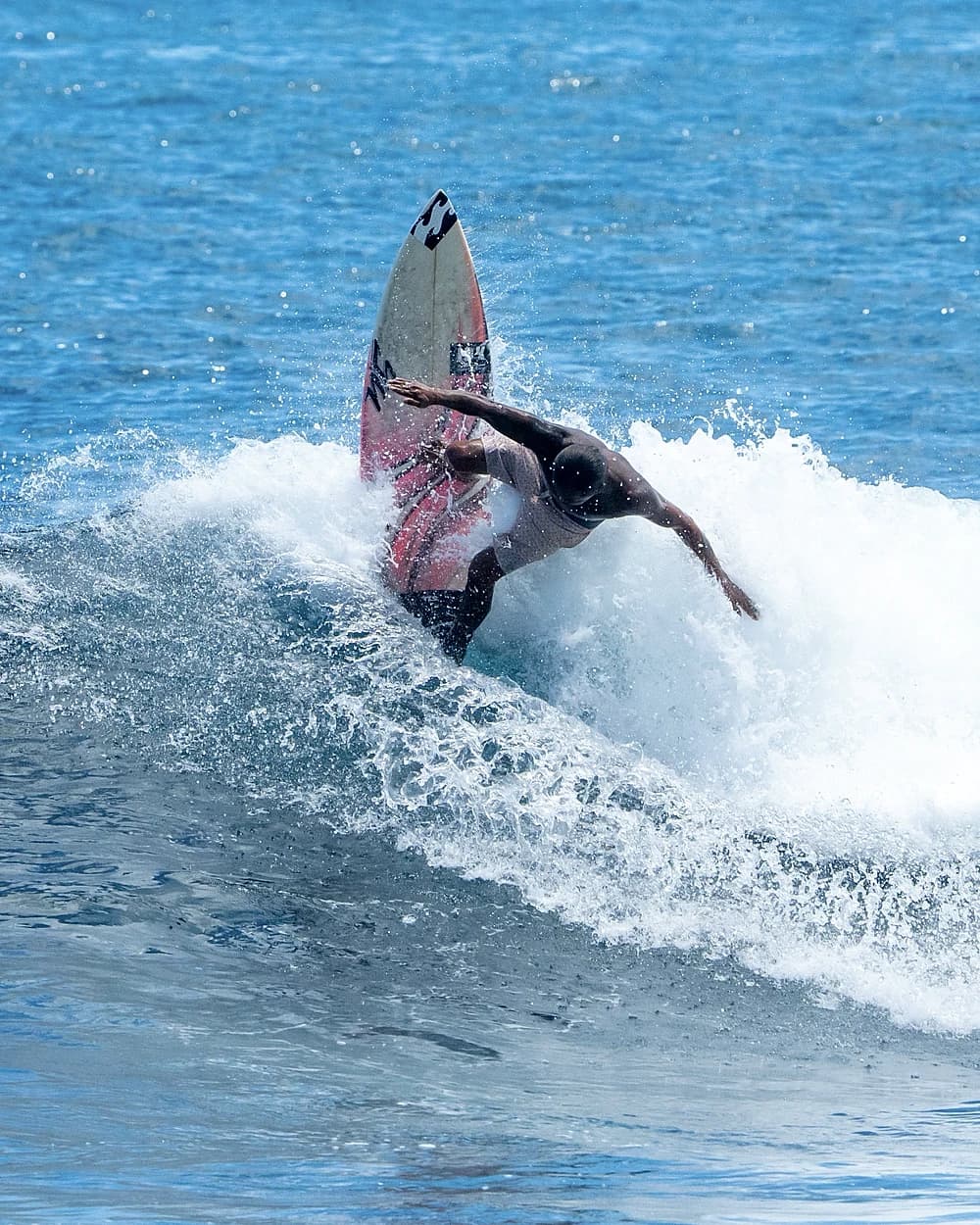 Surfer snapping off the lip with the board vertical at Siargao